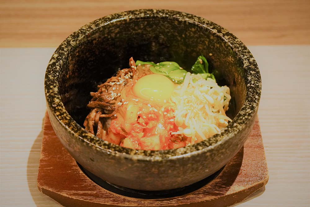 Dolsot Bibimbap (Mixed rice with meat, vegetables, and an egg cooked in a stone pot)